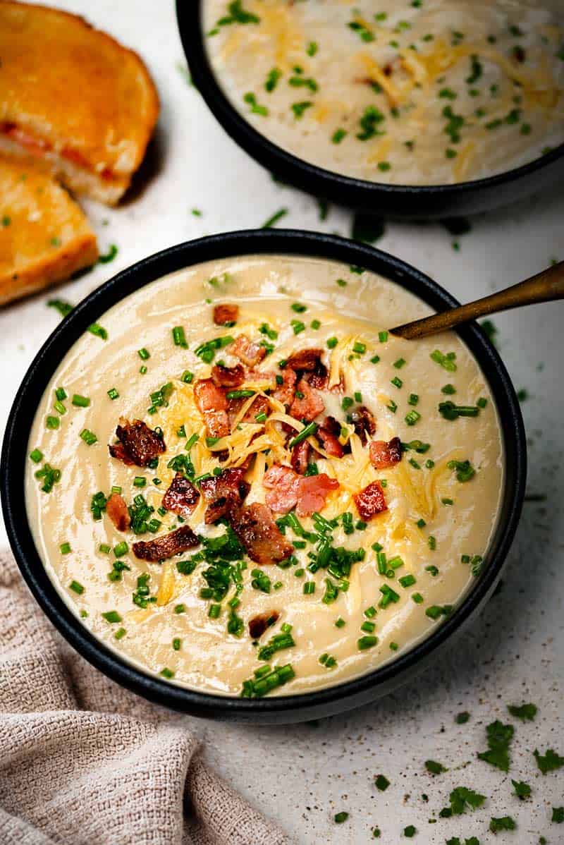 Creamy Cauliflower Soup Blended with cream and served with crispy bacon, chives and shredded cheese.