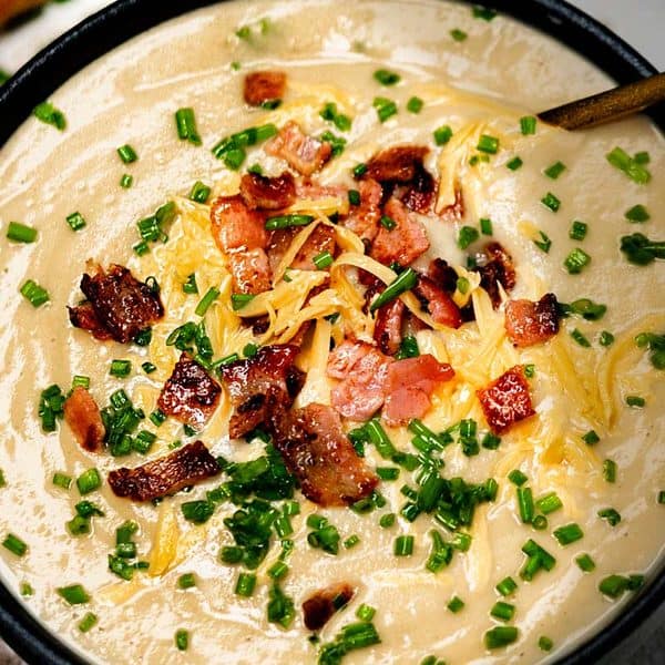 Creamy Cauliflower Soup Blended with cream and served with crispy bacon, chives and shredded cheese.