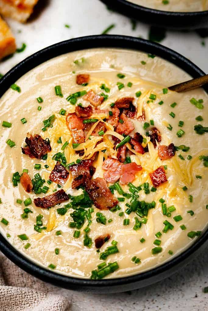 Creamy Cauliflower Soup Blended with cream and served with crispy bacon, chives and shredded cheese.